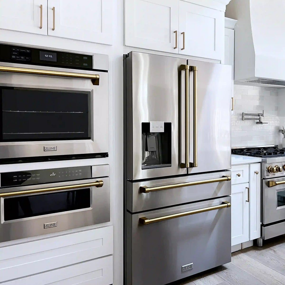 Two stainless steel wall ovens with champagne bronze handles and control panels