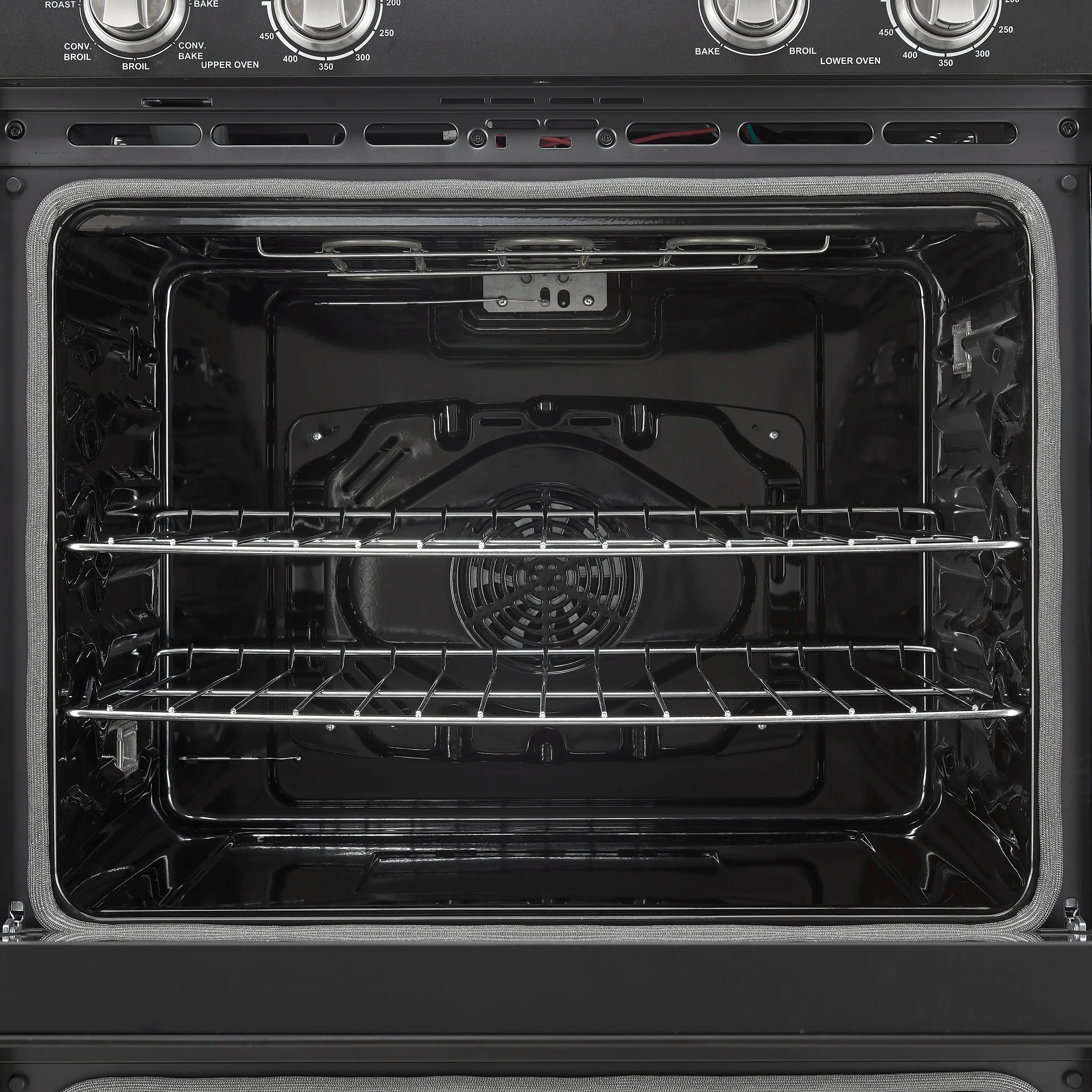Black oven cavity with wire rack shelves and circular convection fan inside.