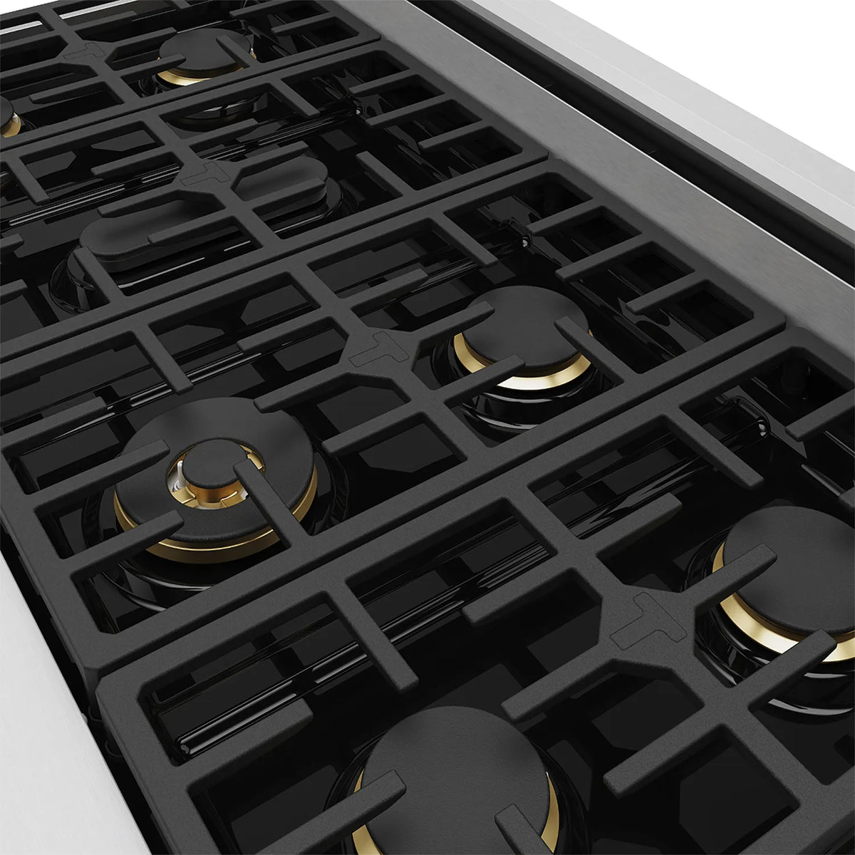 Stainless steel cooktop with black grates and gold-ring burners, close-up