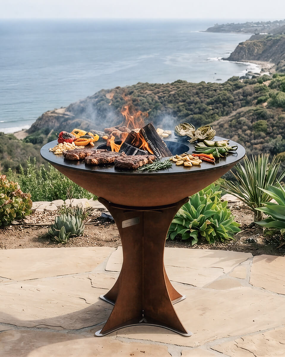 Round flat-top charcoal grill with corten brown pedestal base and open fire