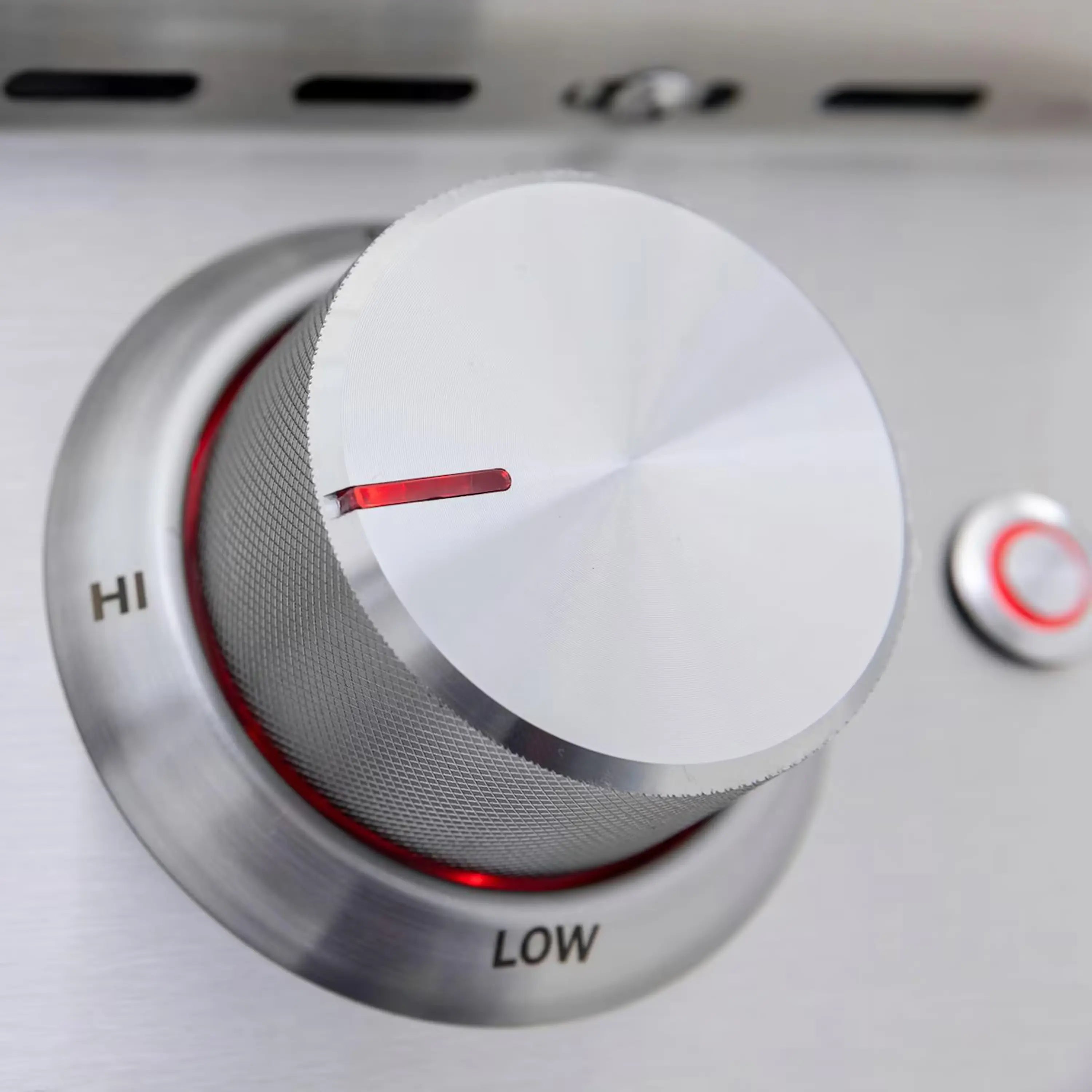Stainless steel burner control knob set to HI with red indicator