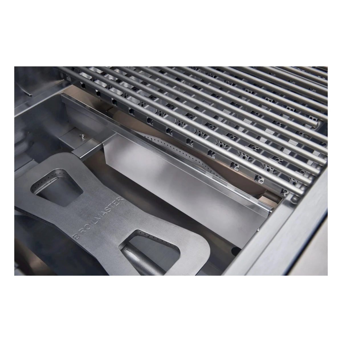 Stainless steel gas grill burner area with angled heat shield and vent holes