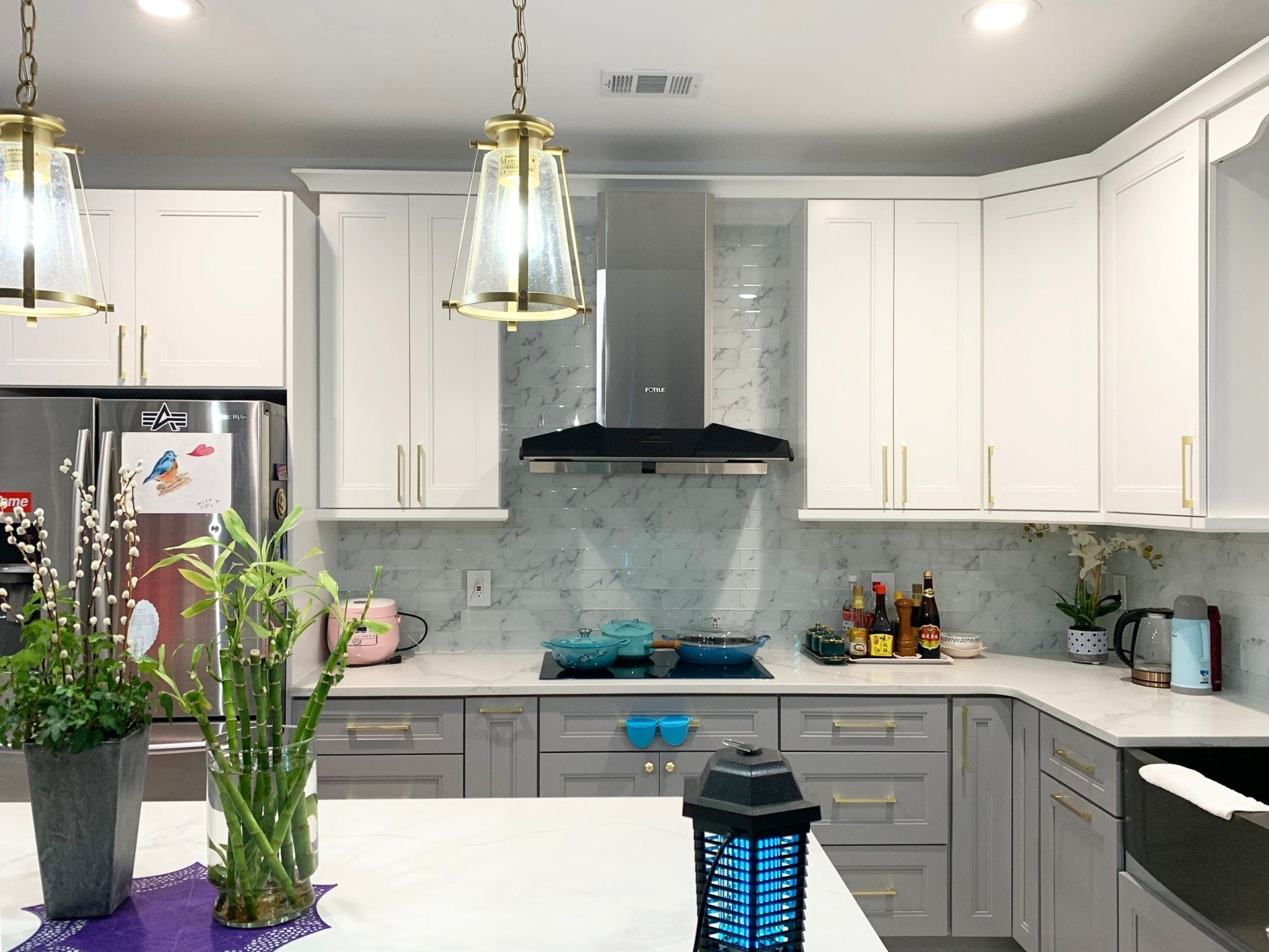 Stainless steel range hood chimney cover installed above cooktop in kitchen