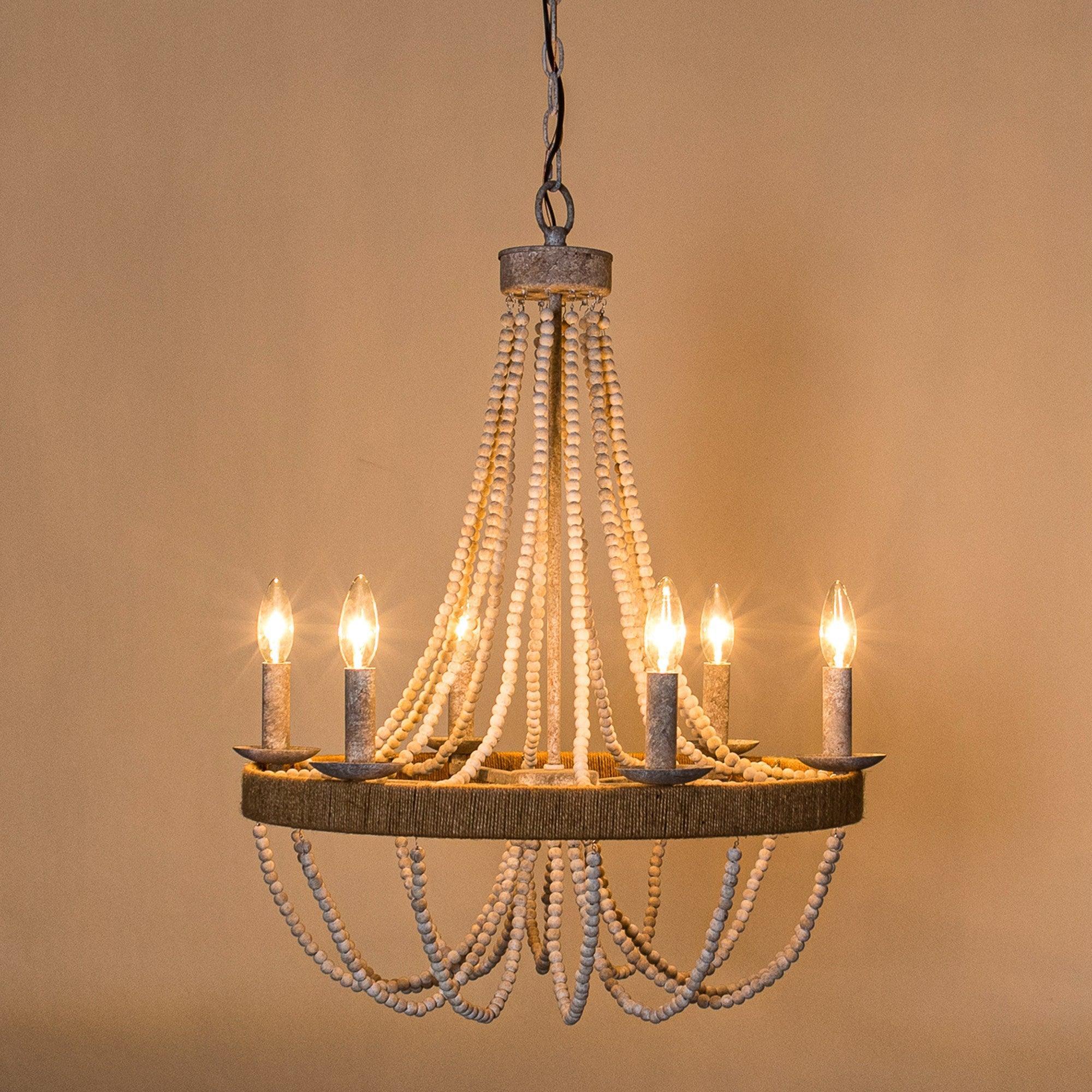 Bead chandelier with white strands, gray cylinder accents, and warm candle-style bulbs lit