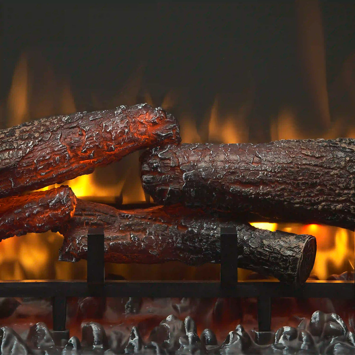 Close-up of glowing electric fire logs with ember bed and orange flame effect
