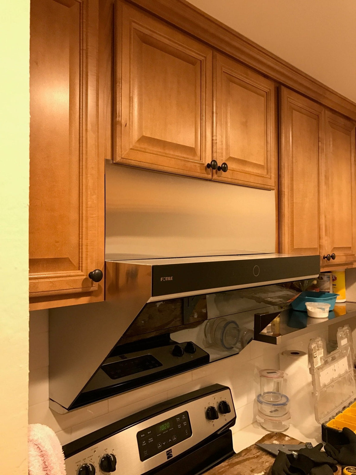 Black decorative vent panel on a slant range hood, integrated rectangular face