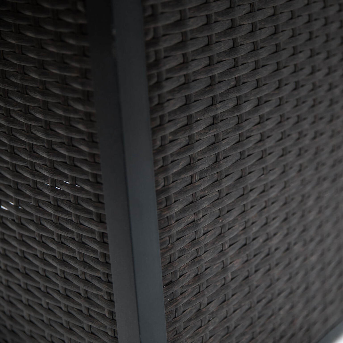 Dark woven side panel of the outdoor gas firepit table with angled support leg