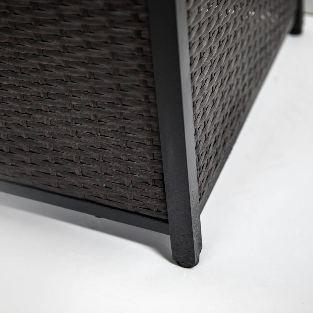 Lower leg and dark woven texture of the outdoor firepit table body