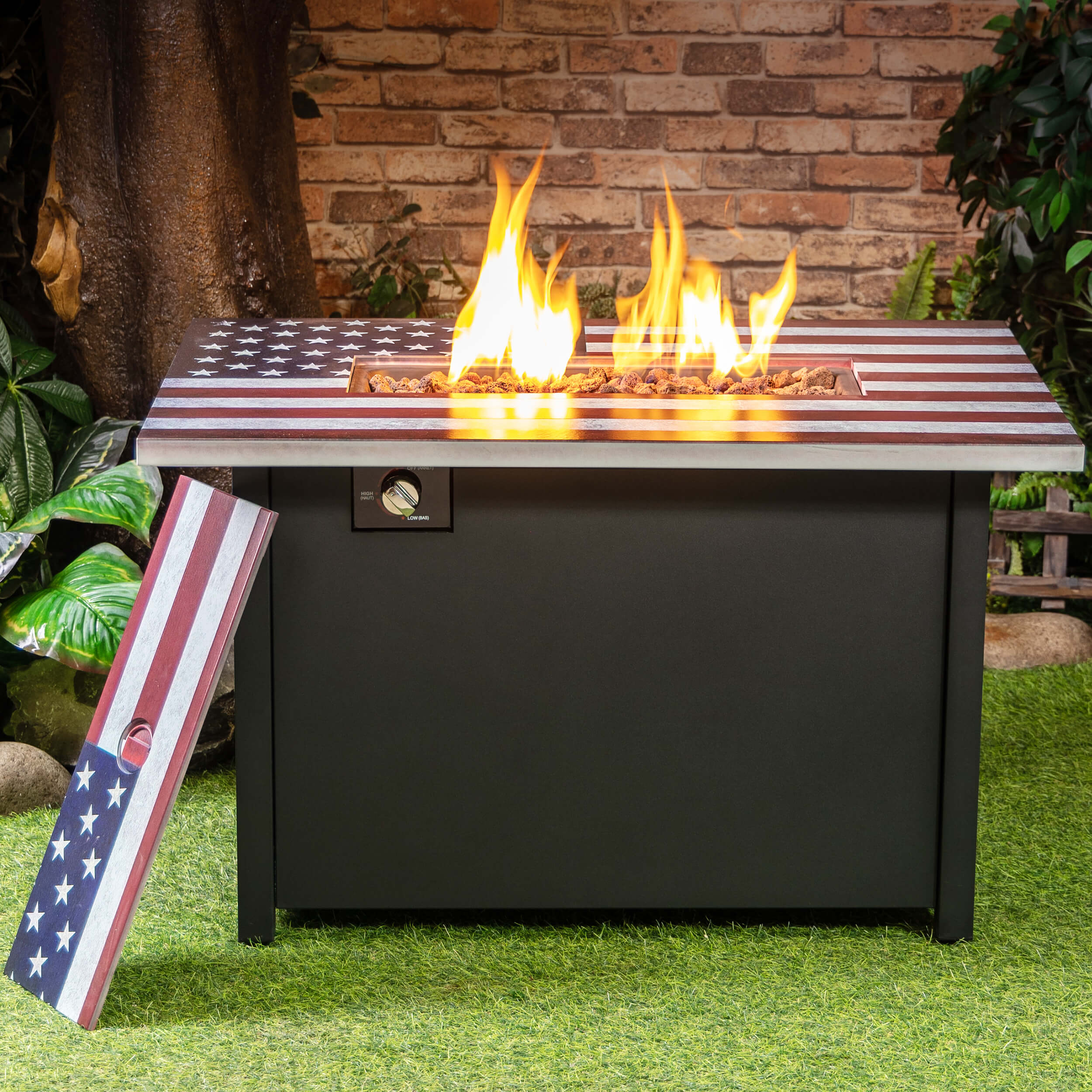 Outdoor propane fire table with flames visible under American flag-style lid