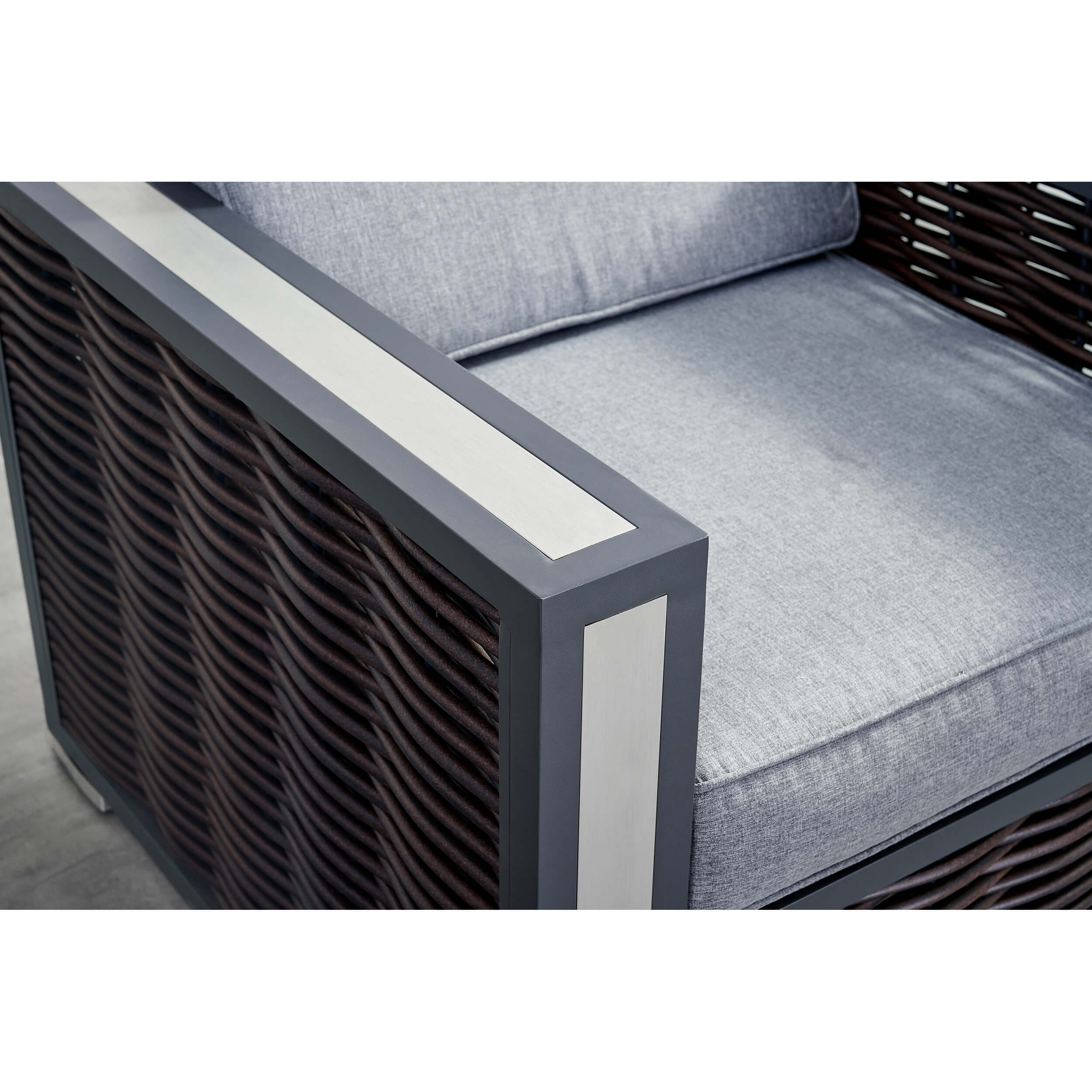 Outdoor chair armrest detail with light-gray cushion and dark woven side panel