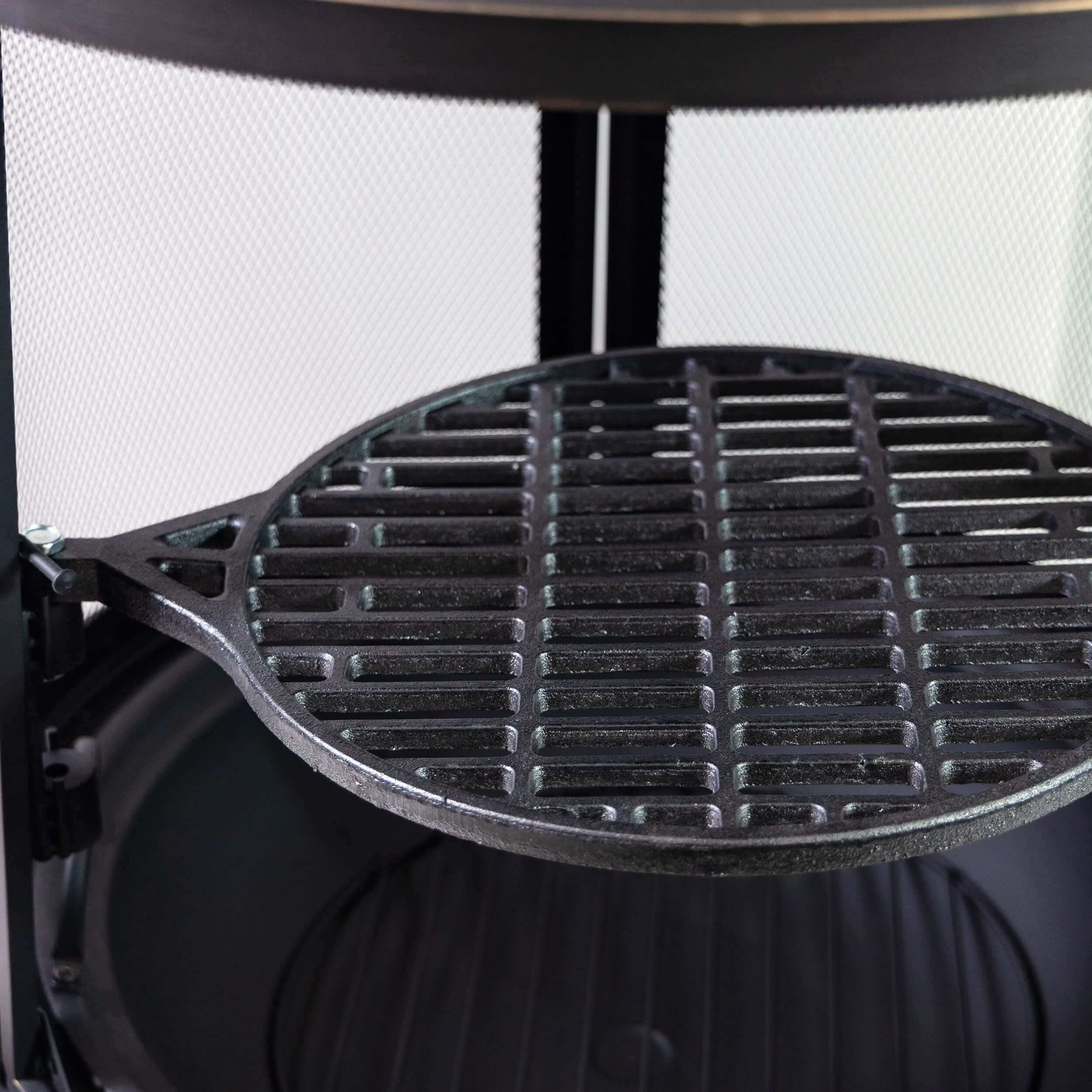 Round firepit grill grate with raised bars inside the mesh-front opening