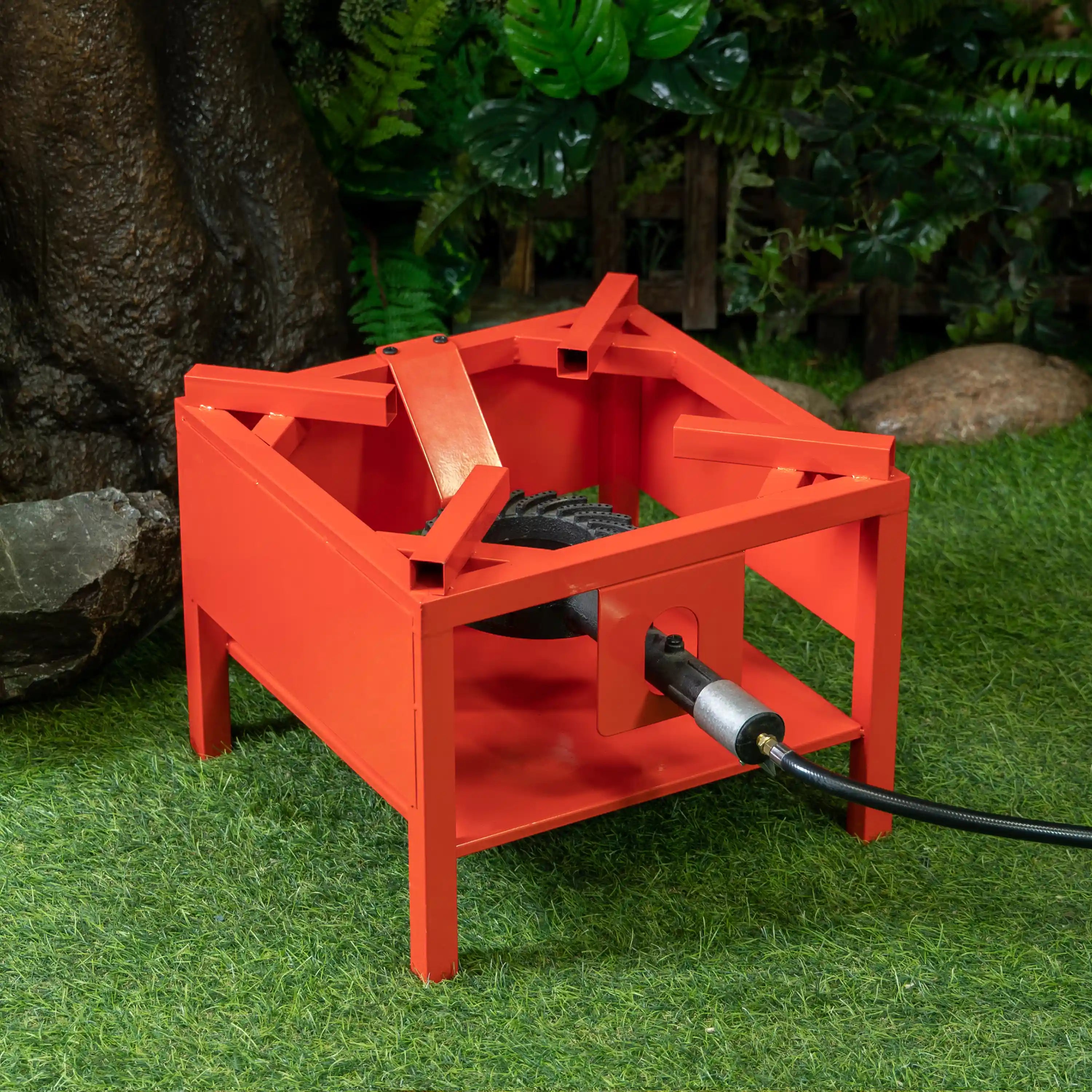 Red outdoor propane burner stand with black burner tube and connected hose