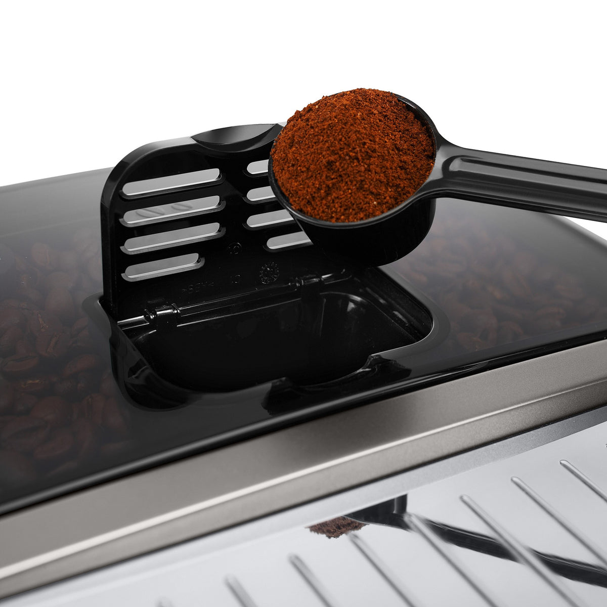 Coffee bean grinder chute with grounds in the brew tray of a super automatic machine