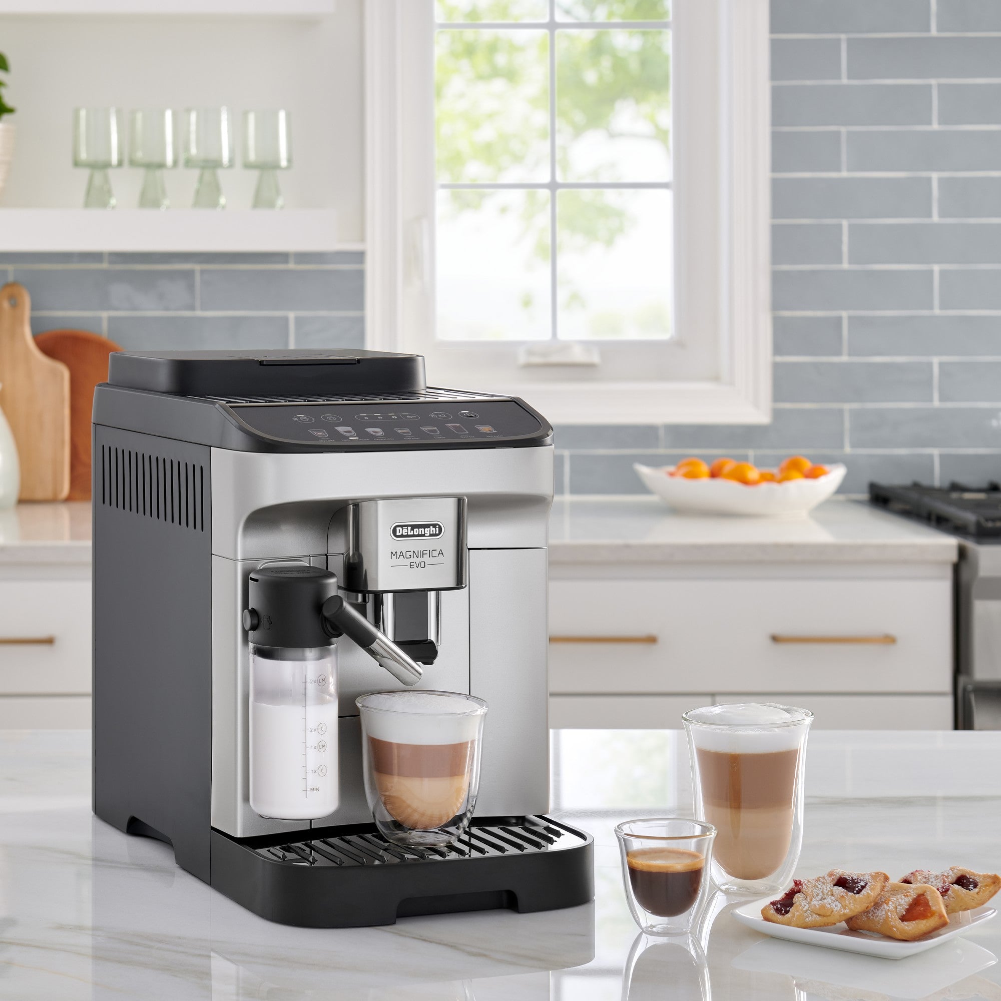 De'Longhi Magnifica Evo coffee machine pouring a drink into a cup next to pastries