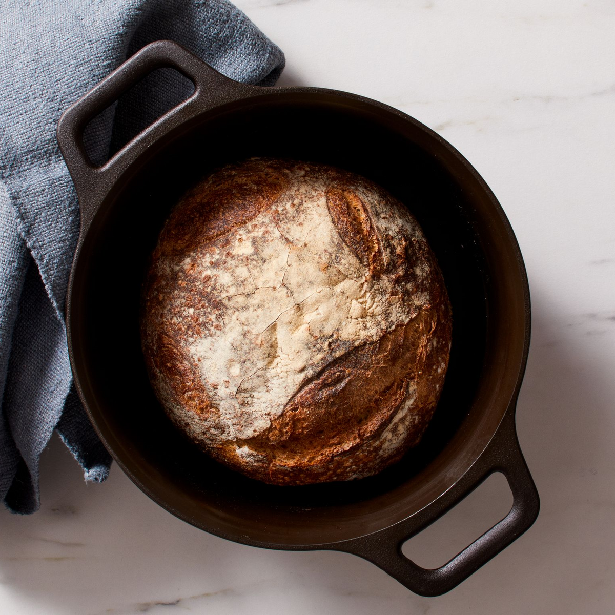 Field Company cast iron dutch oven holding bread loaf, dark interior