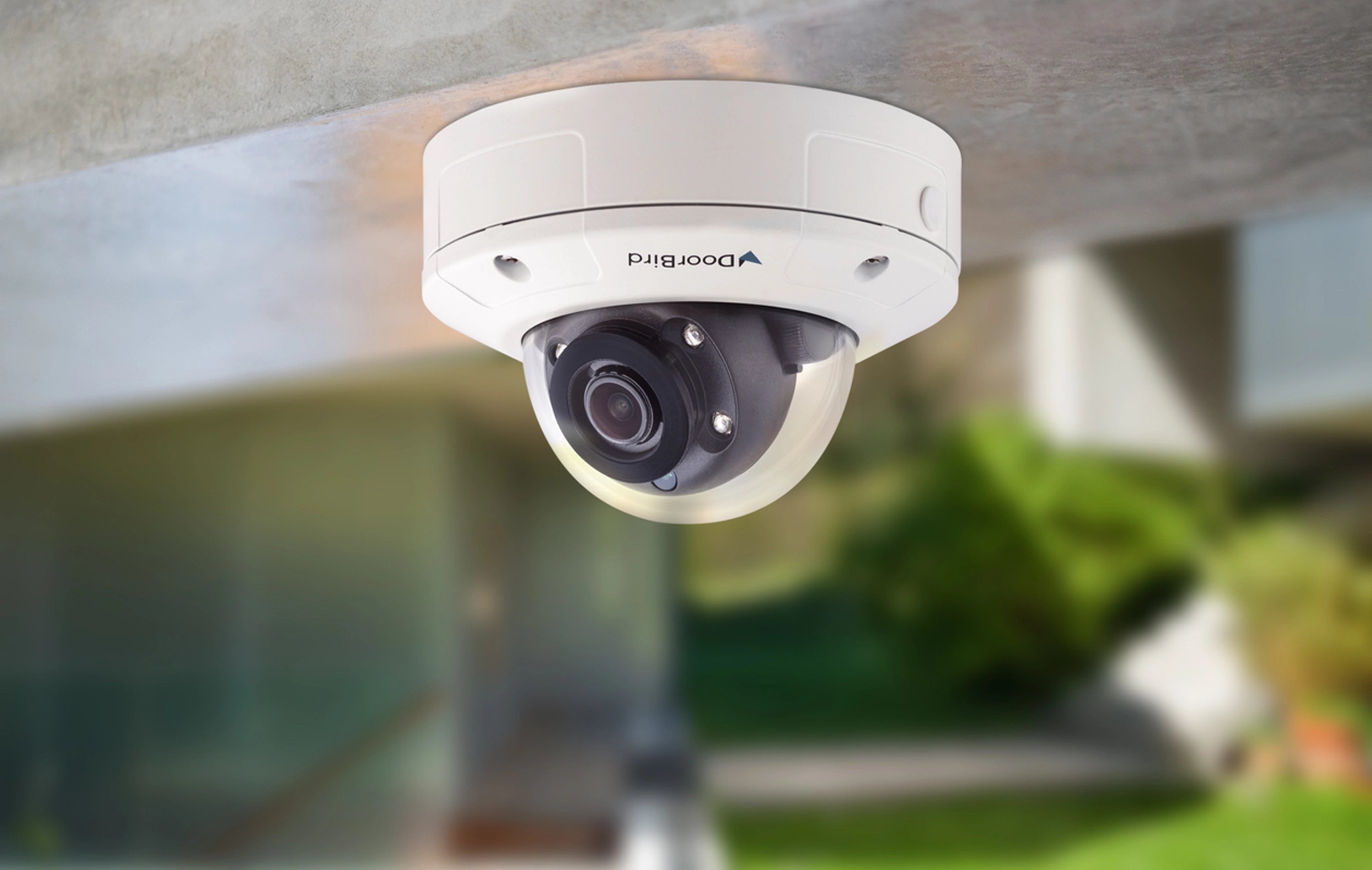 DoorBird mini dome IP video camera, white, underside view with lens and mounting plate.