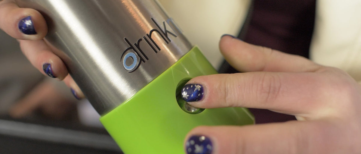 Drinkmate CO2 cartridge being inserted into a countertop canister with green collar