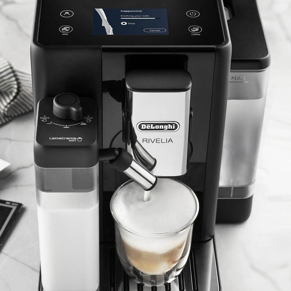 Close-up of black espresso machine dispensing into a glass cup.