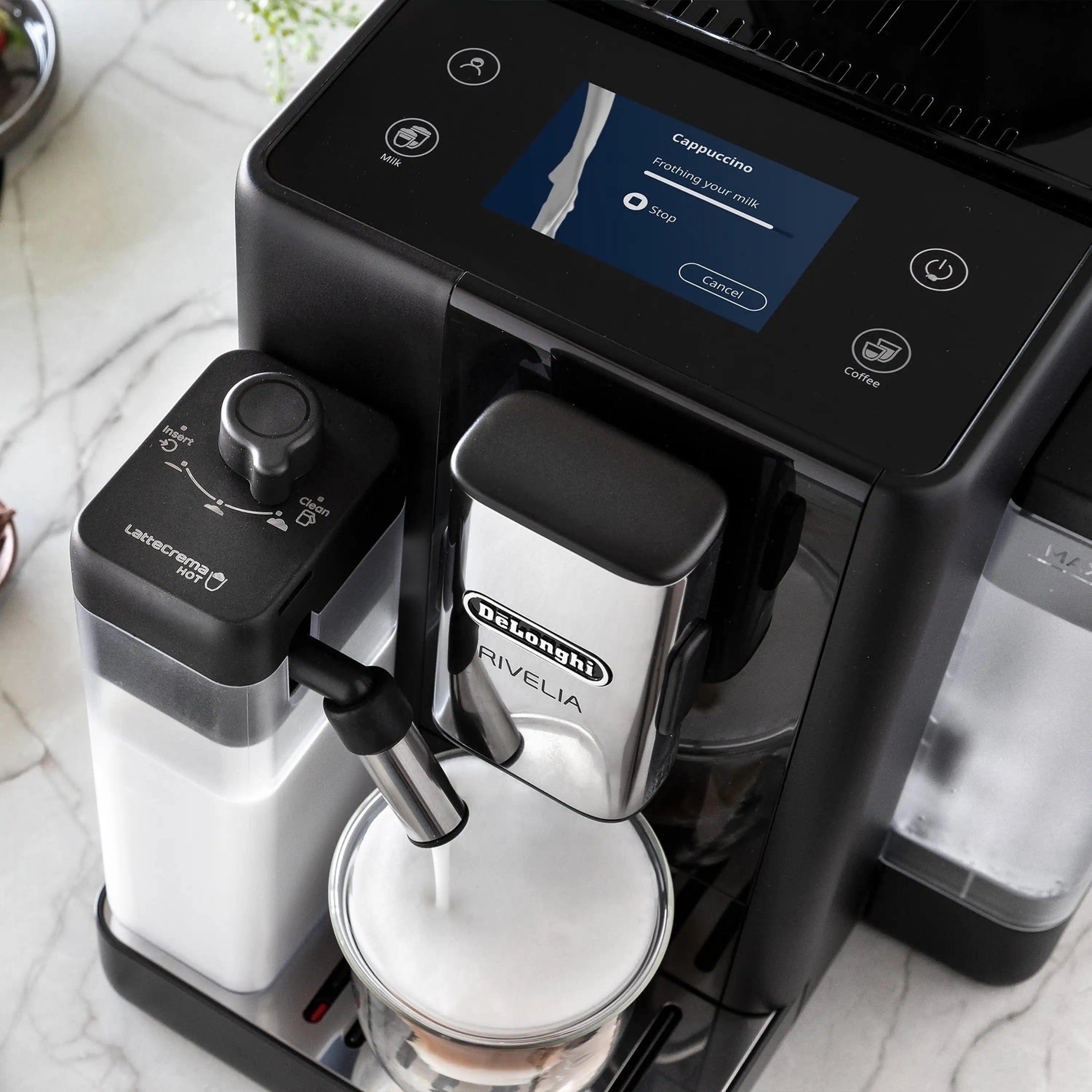 Black espresso machine with frothing nozzle and display menu on screen.