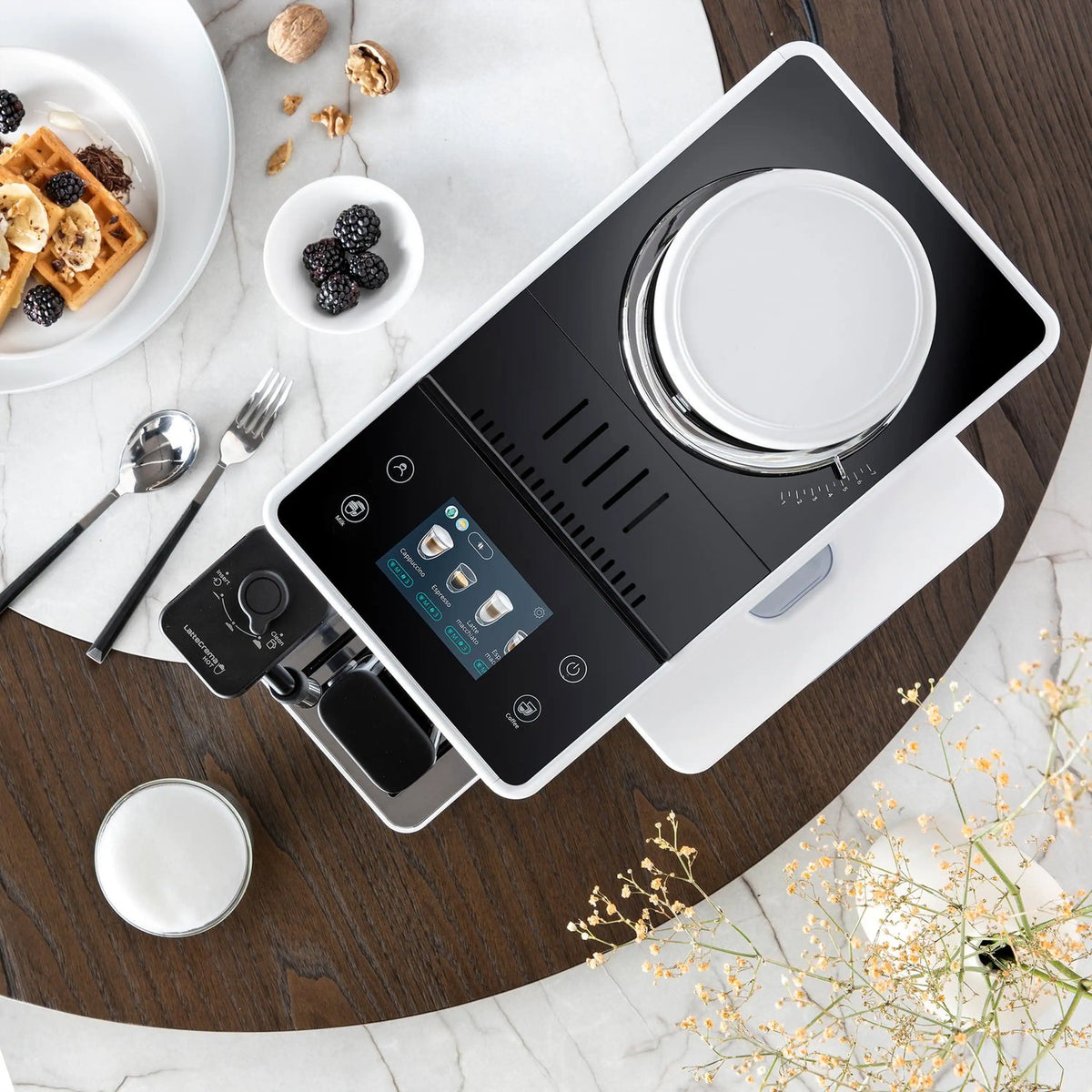 White espresso machine on tabletop with touchscreen control panel and accessories