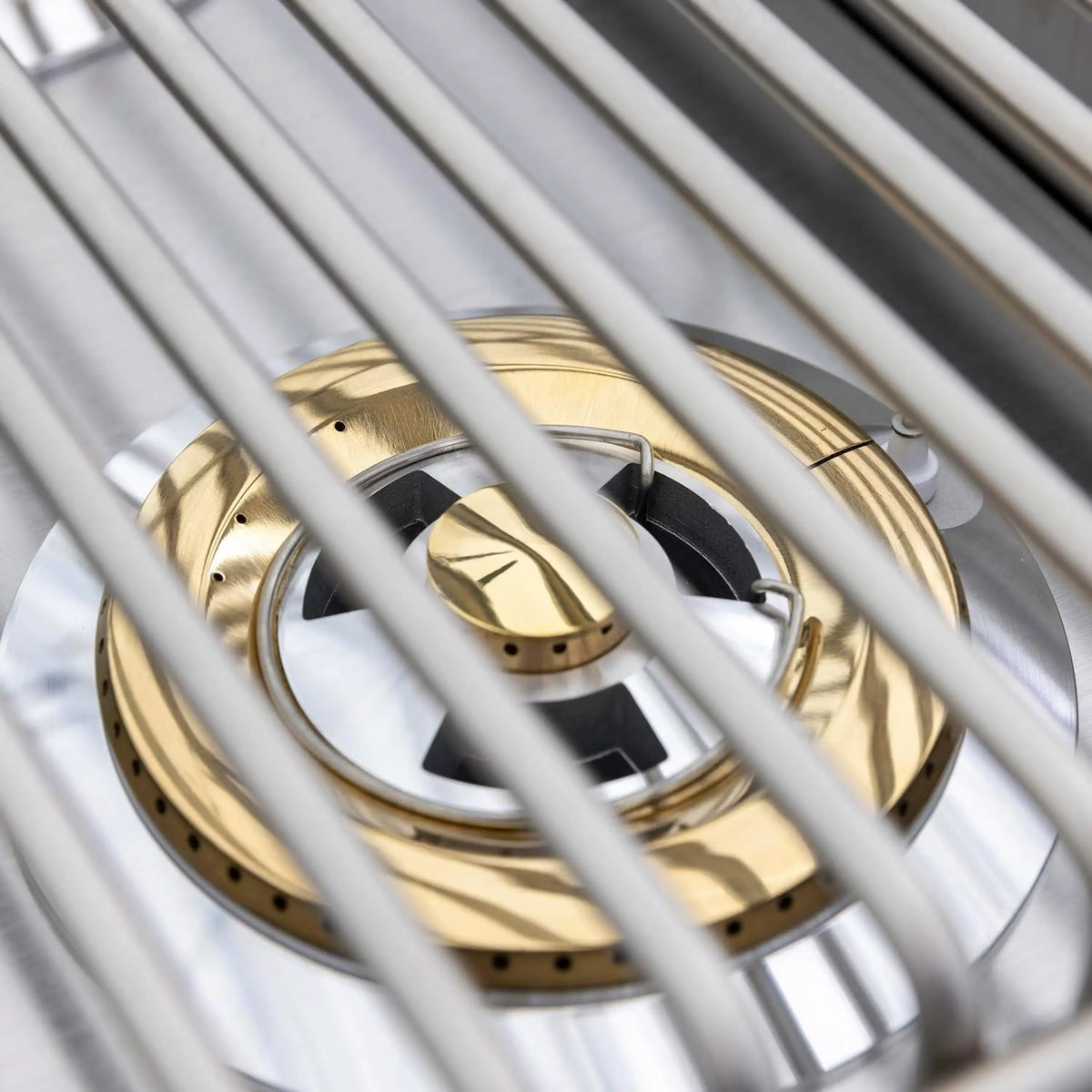 Close-up of dual gas burner grates and brass burner caps