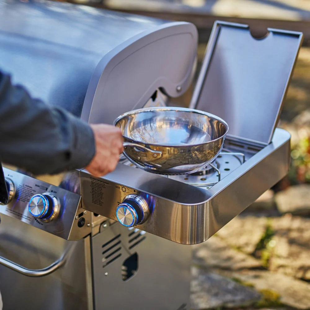 Stainless grill side view with opened lid and bowl warming over the burners