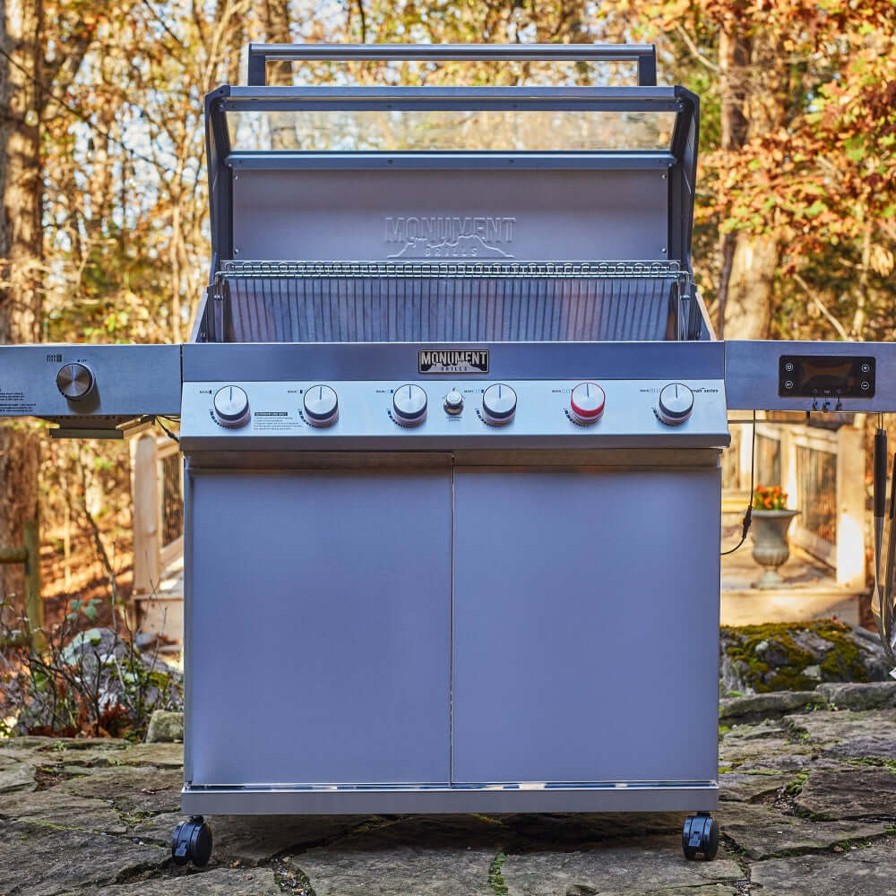Stainless steel 6-burner gas grill with open hood, control knobs, and side shelf
