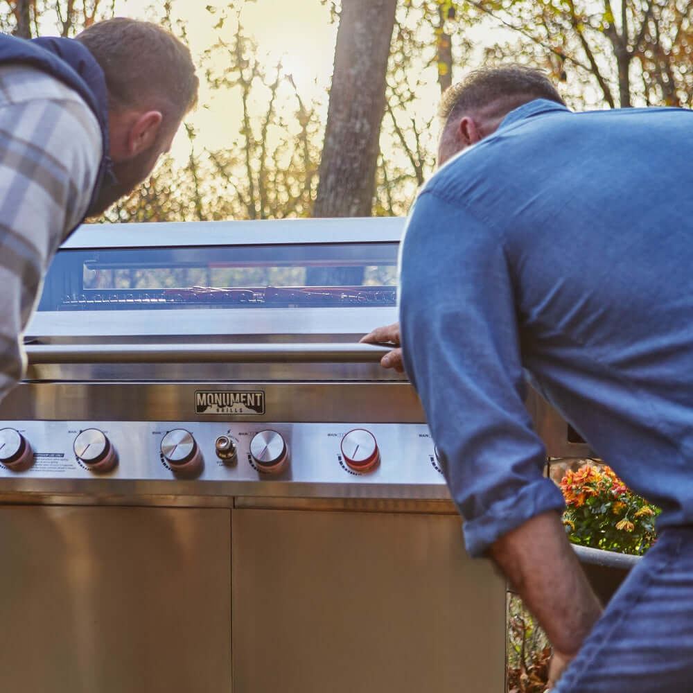 Stainless steel gas grill with front control knobs and open lid