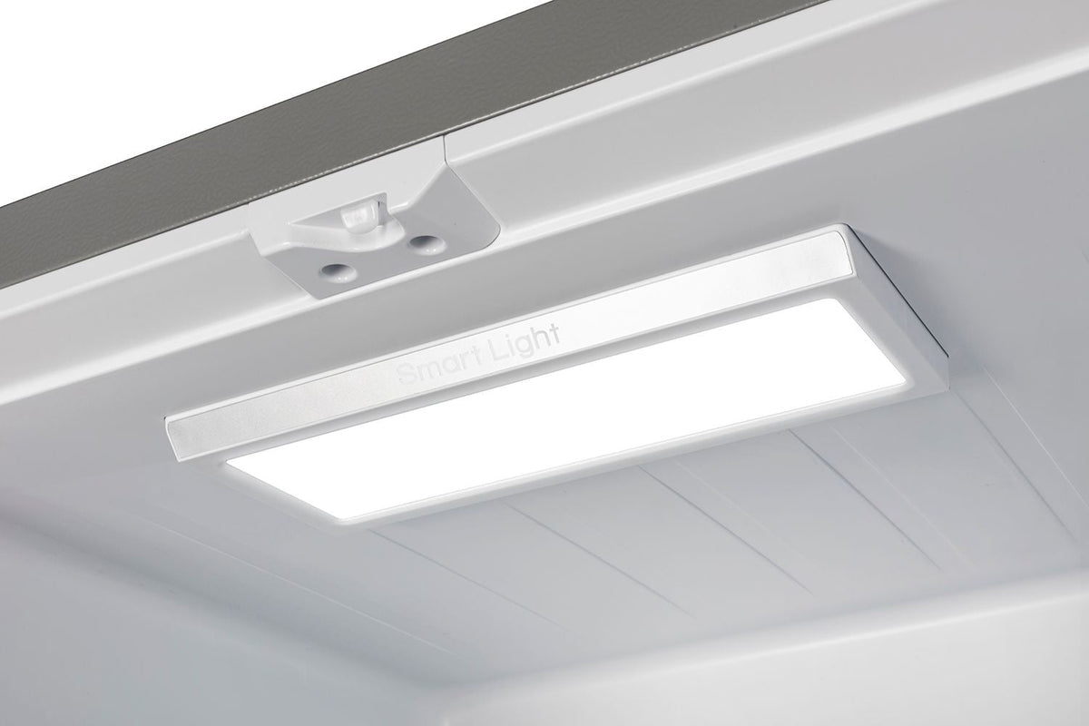 Refrigerator ceiling light and vent panel inside upper compartment.