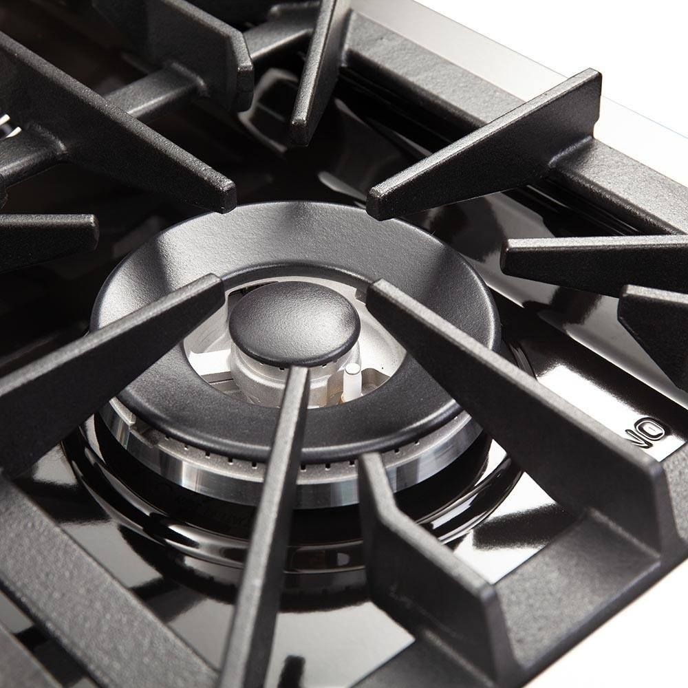 Dual fuel range burner close-up with black grate and metal burner cap