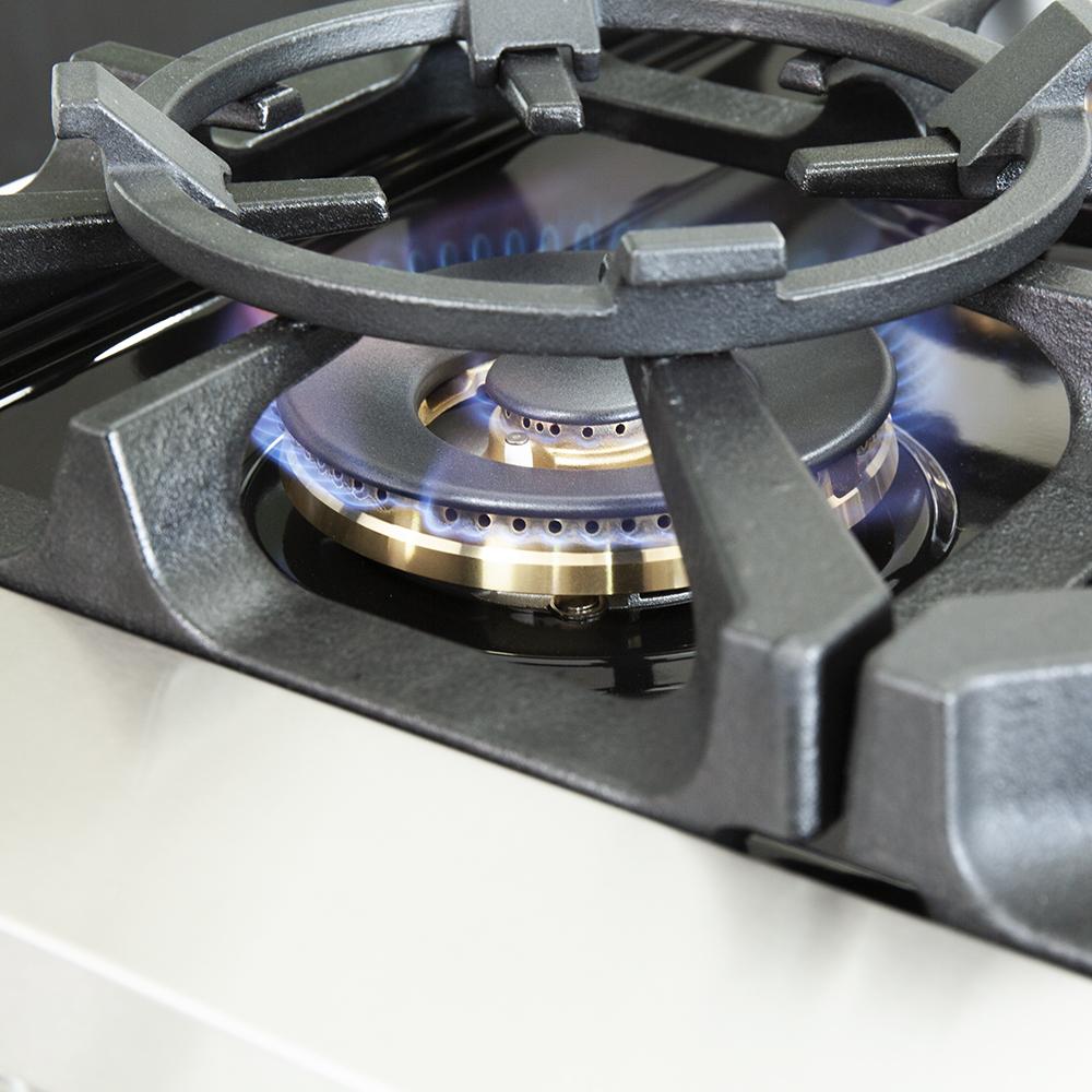 Close-up of a gas burner with blue flame and metal burner cap