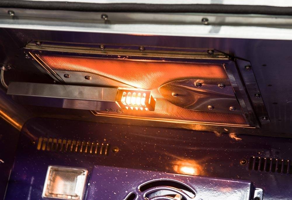 Gas range oven burner area with glowing lights and metal heat shields