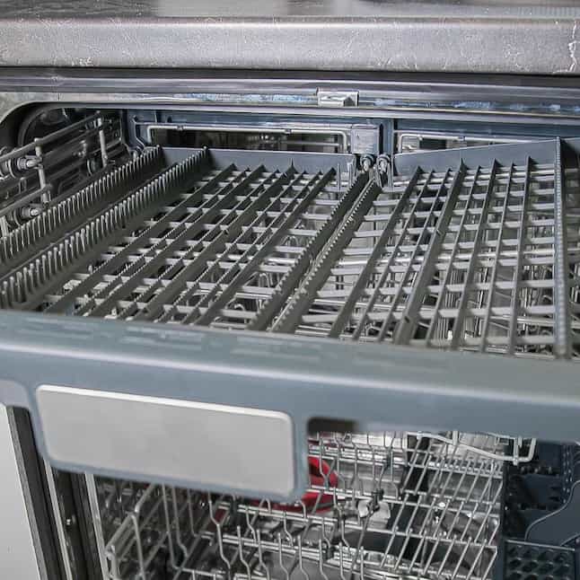 Dishwasher interior view with lower rack and stainless steel tines