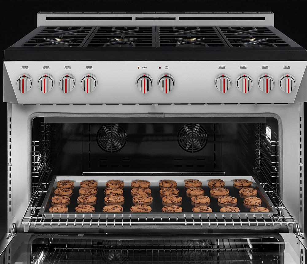 Gas range oven interior with baking tray of cookies and wire rack