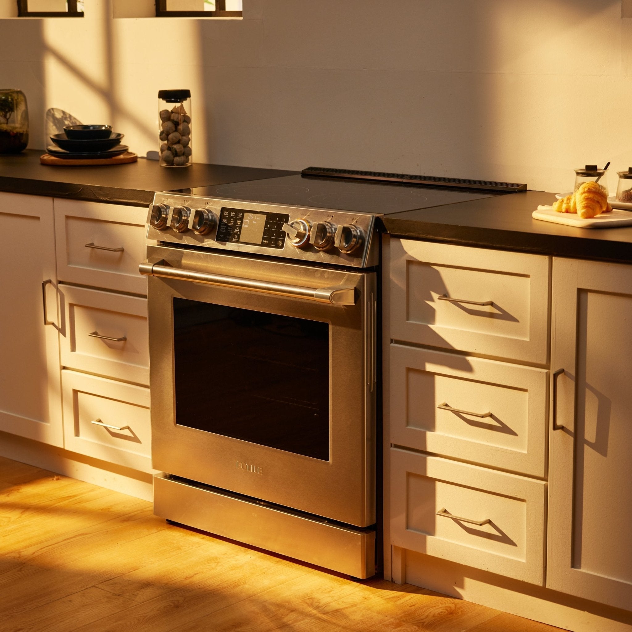 Stainless slide-in electric range with oven door closed and control knobs