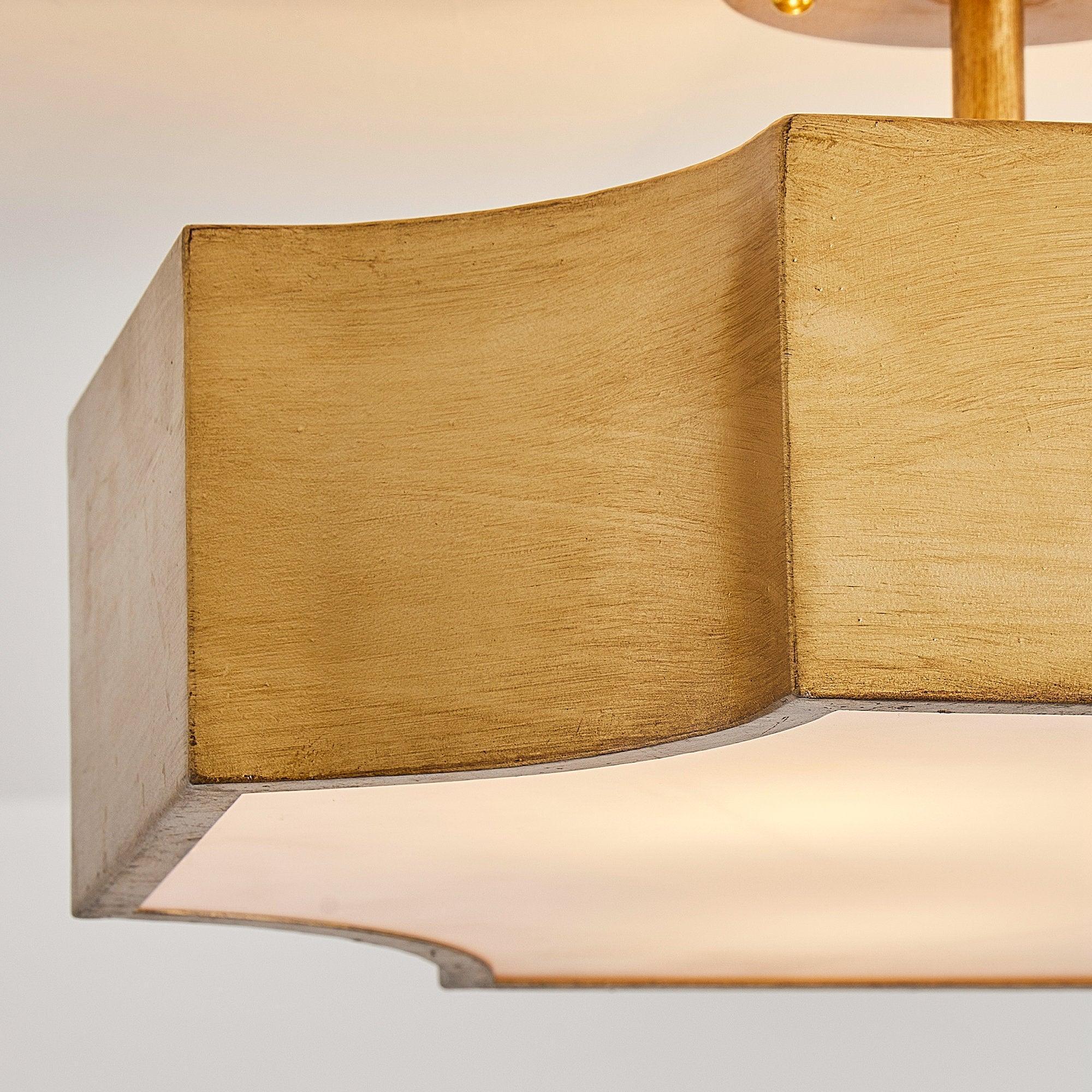 Brushed gold semi-flush mount light with textured shade panels and white acrylic diffuser