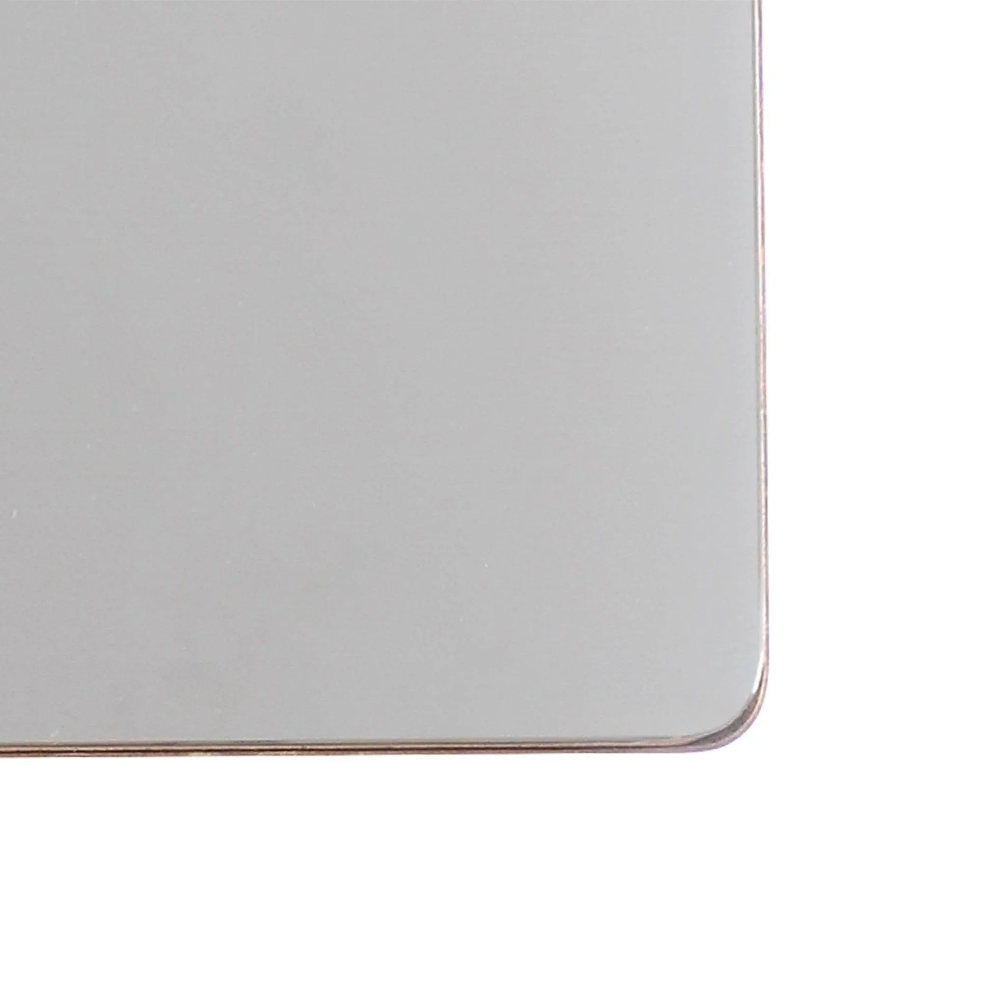 Close-up of square mirror edge with gold-toned metal frame and rounded corners