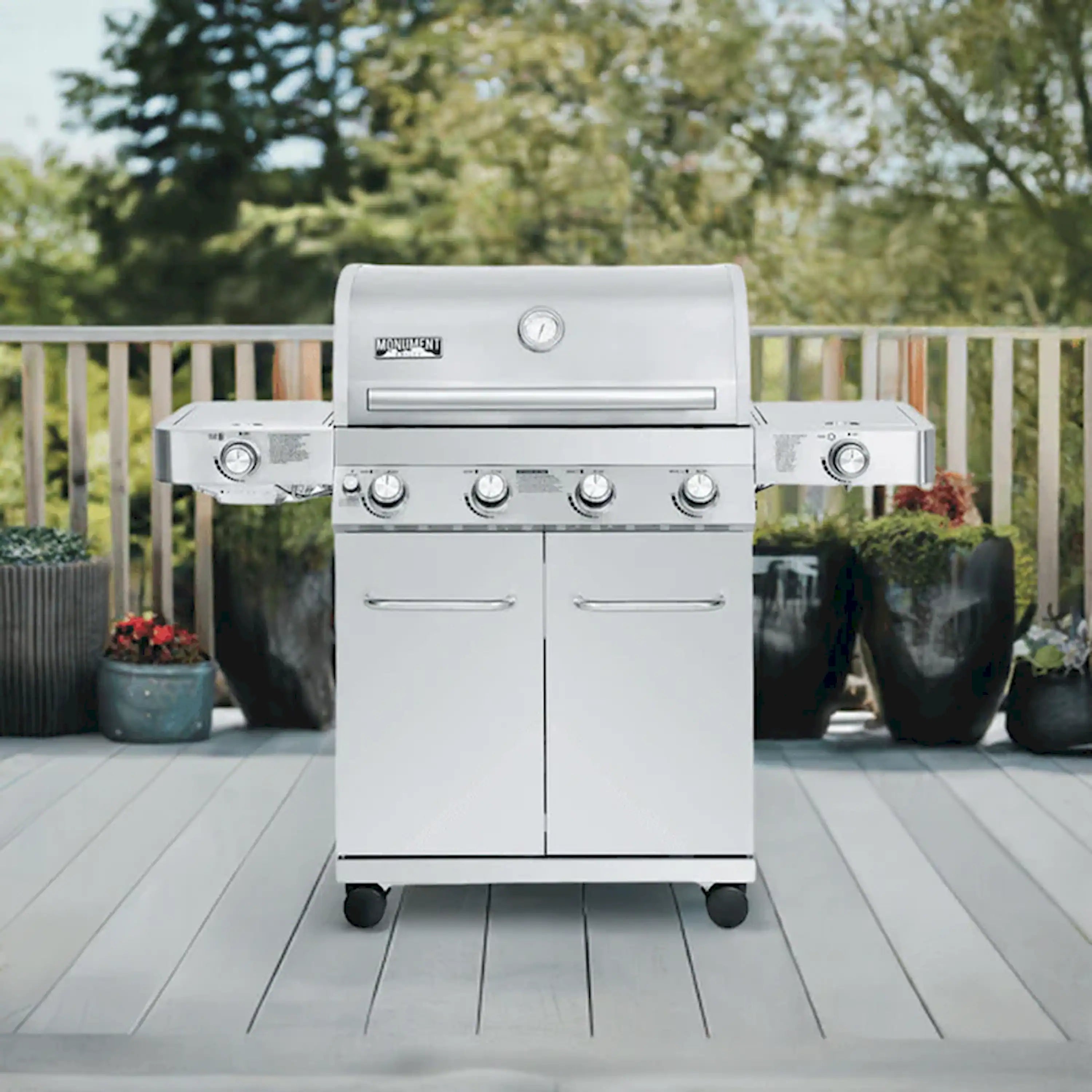 Stainless steel propane gas grill with side control panel and two cabinet doors