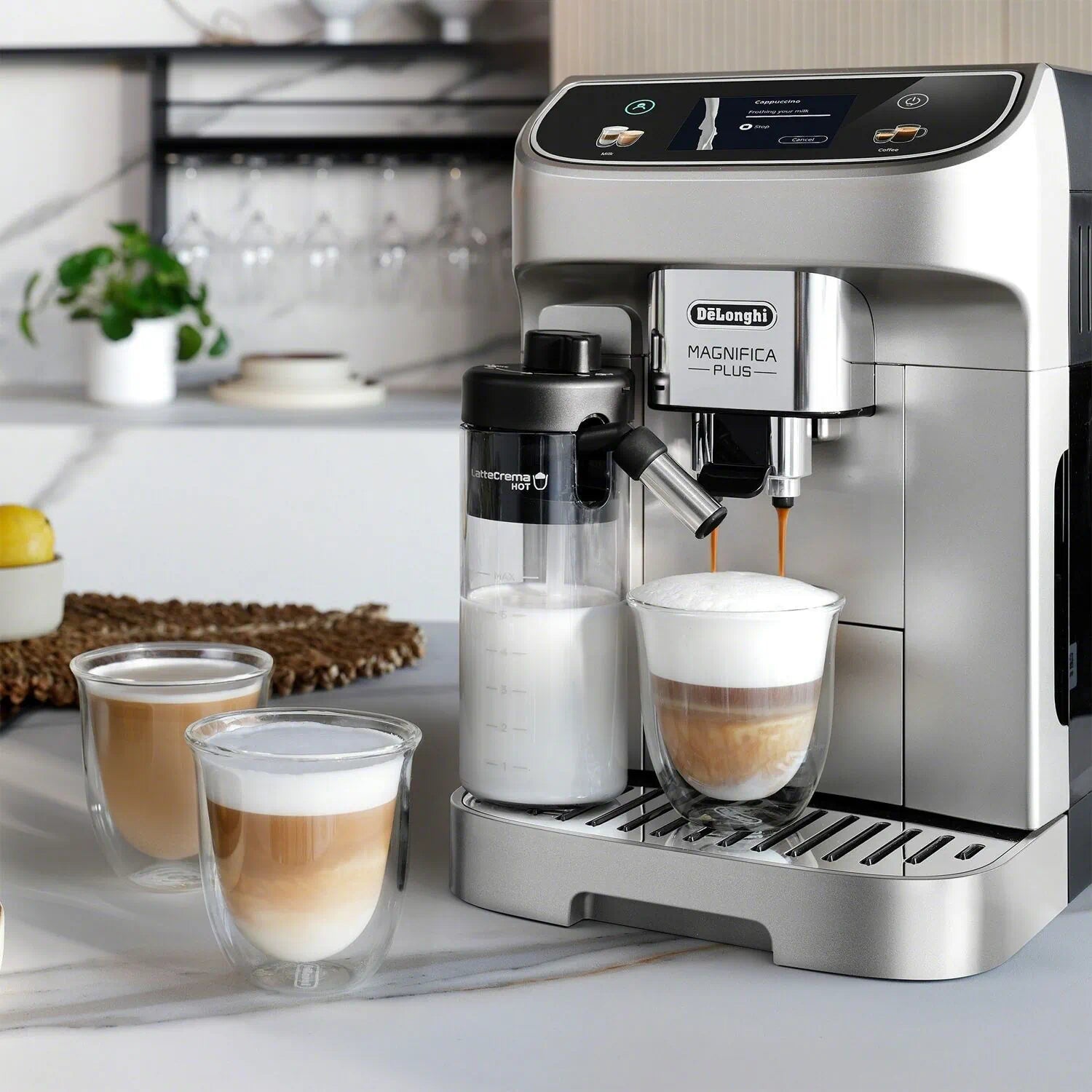 Silver fully automatic espresso machine making drinks with frothing carafe and front cups
