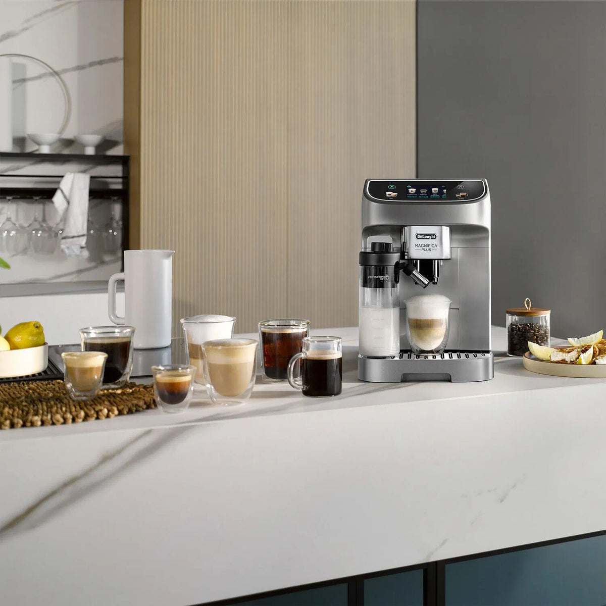 Silver fully automatic espresso machine on countertop with multiple cups and coffee accessories