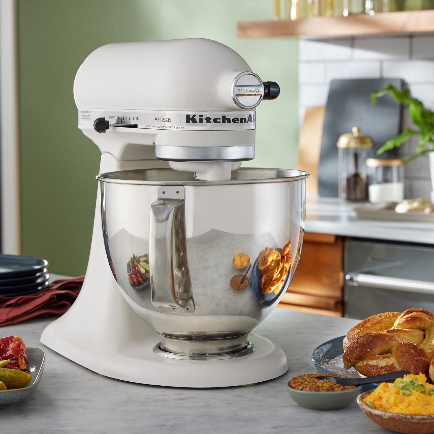 Porcelain tilt-head stand mixer with stainless bowl on countertop, ready for mixing