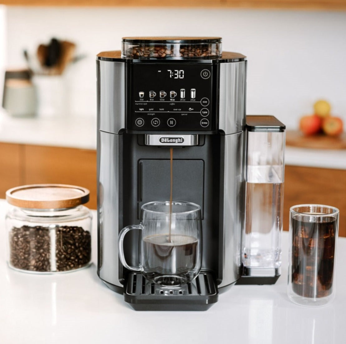 Black and stainless De'Longhi automatic coffee maker with cups and bean containers