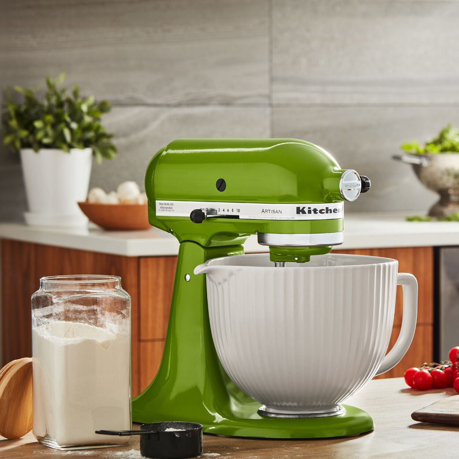 Matcha green tilt-head stand mixer with stainless bowl on a kitchen counter