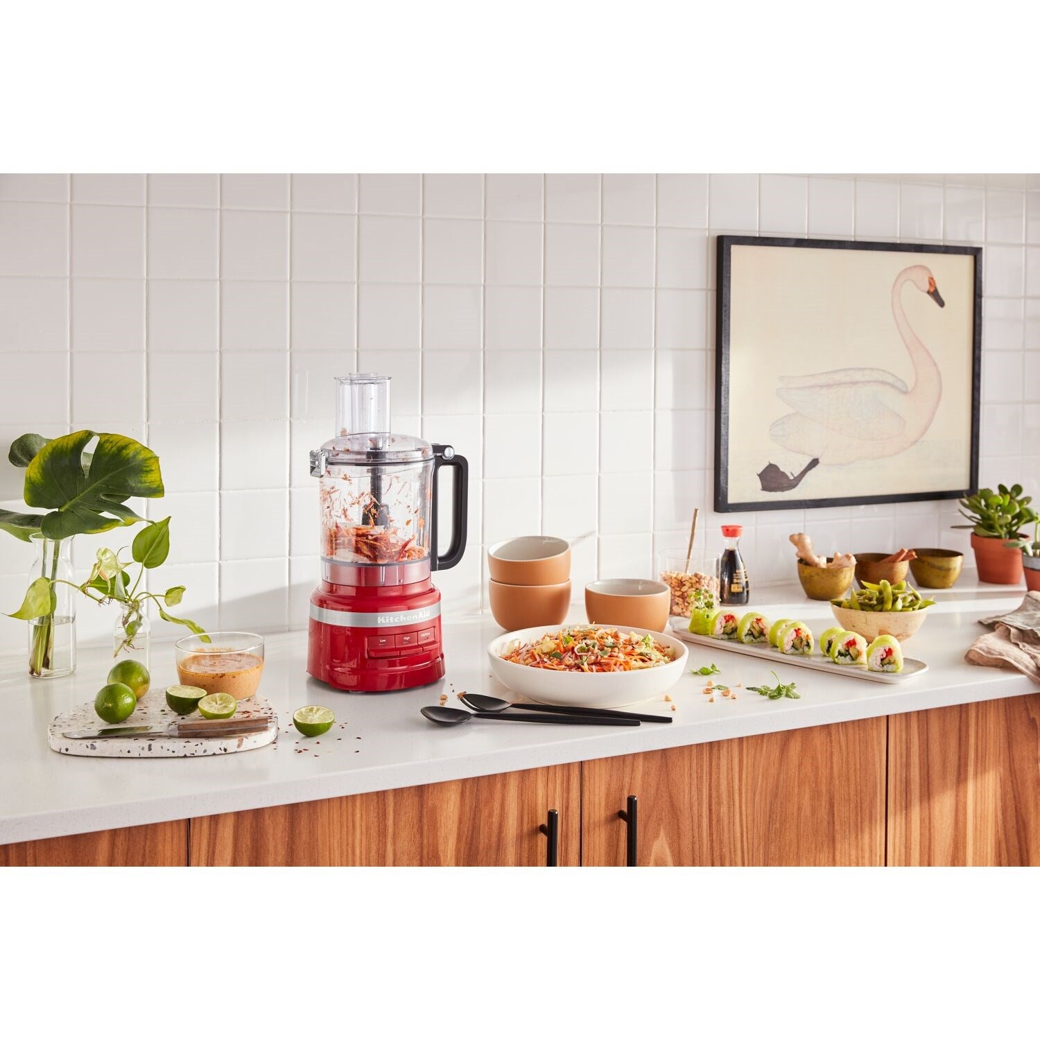 KitchenAid food processor on countertop with clear lid and red base