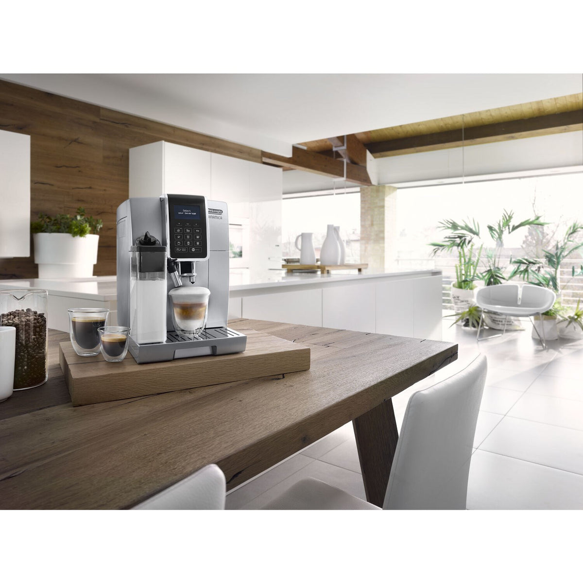 Silver super-automatic espresso machine on kitchen countertop with cup stand