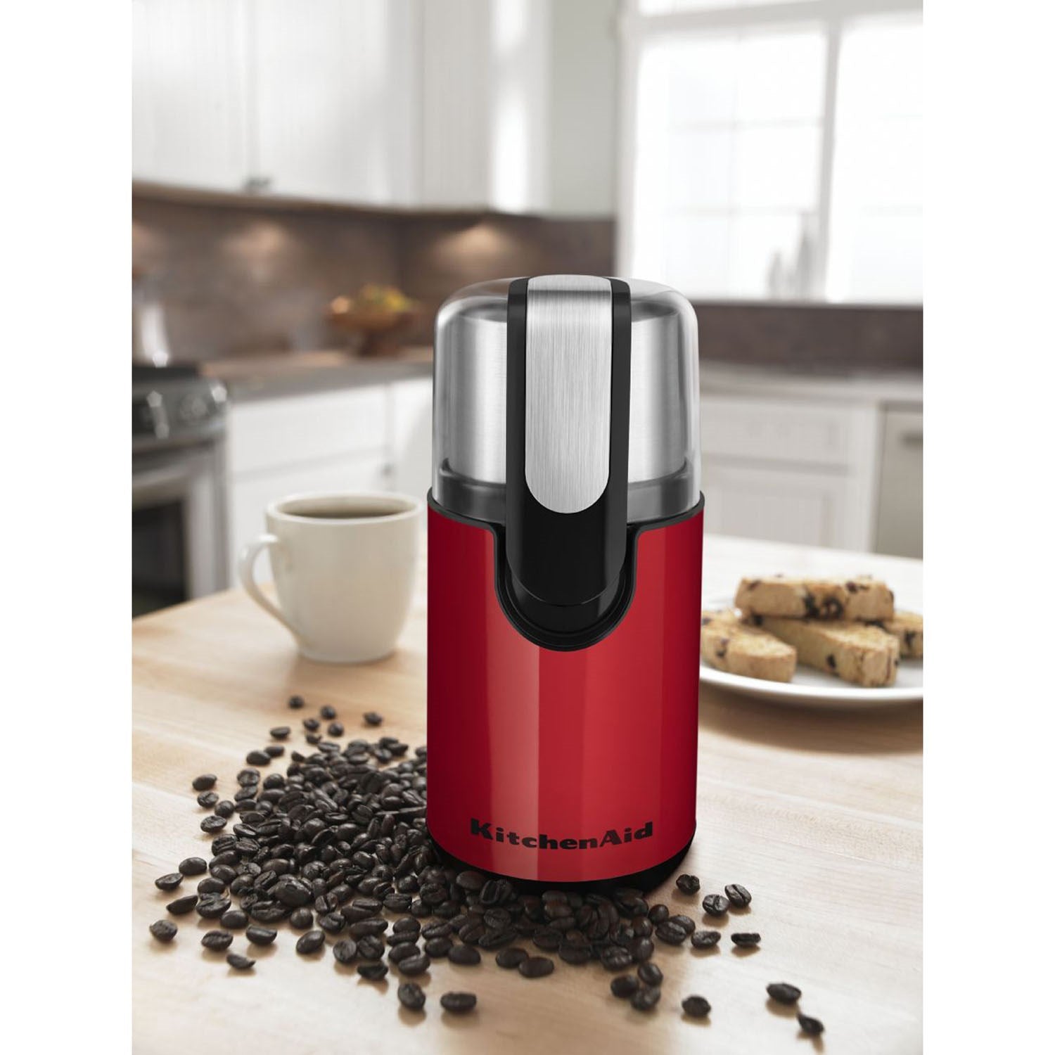 Red KitchenAid blade coffee grinder on counter with stainless lid and black base
