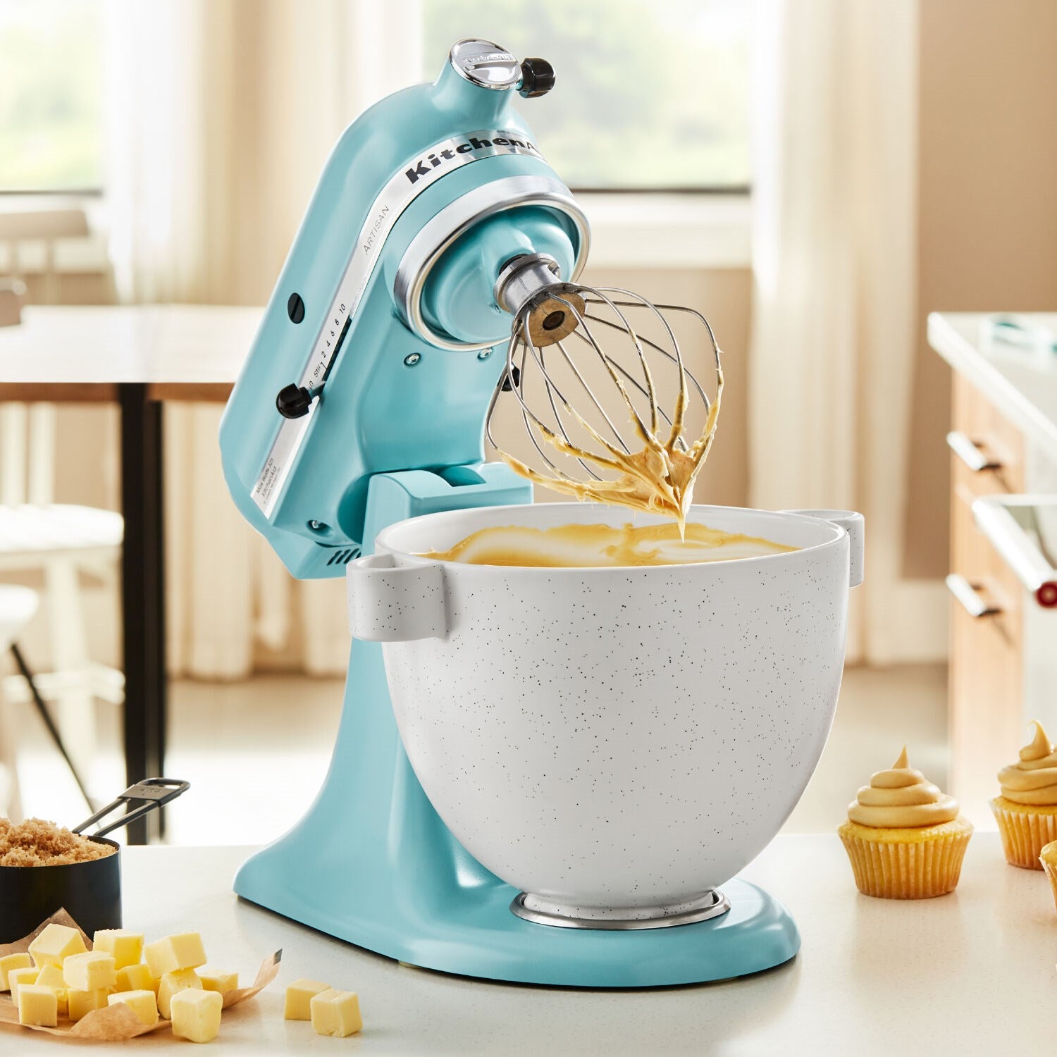 Mineral water blue tilt-head stand mixer with whisk over stainless bowl