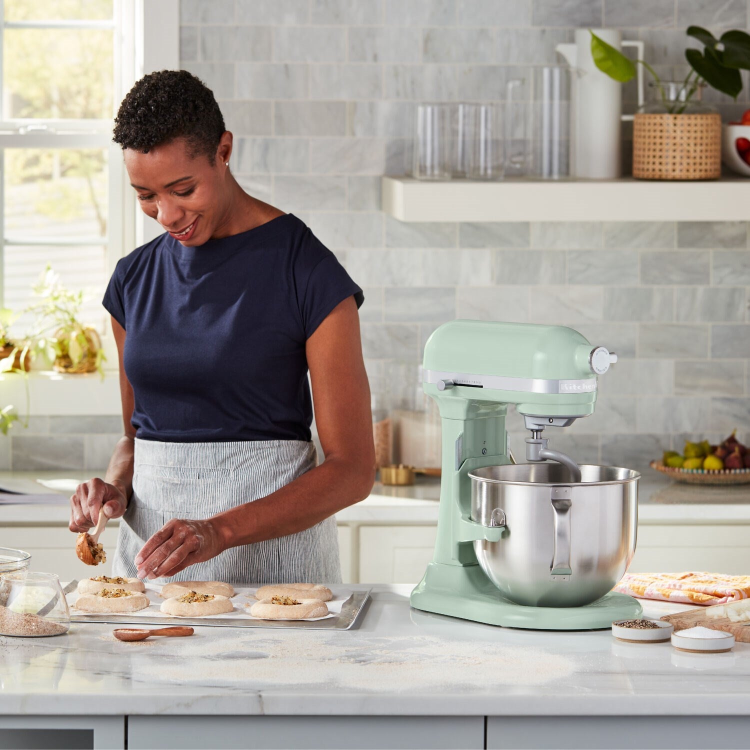 Pistachio green KitchenAid stand mixer with stainless bowl on countertop