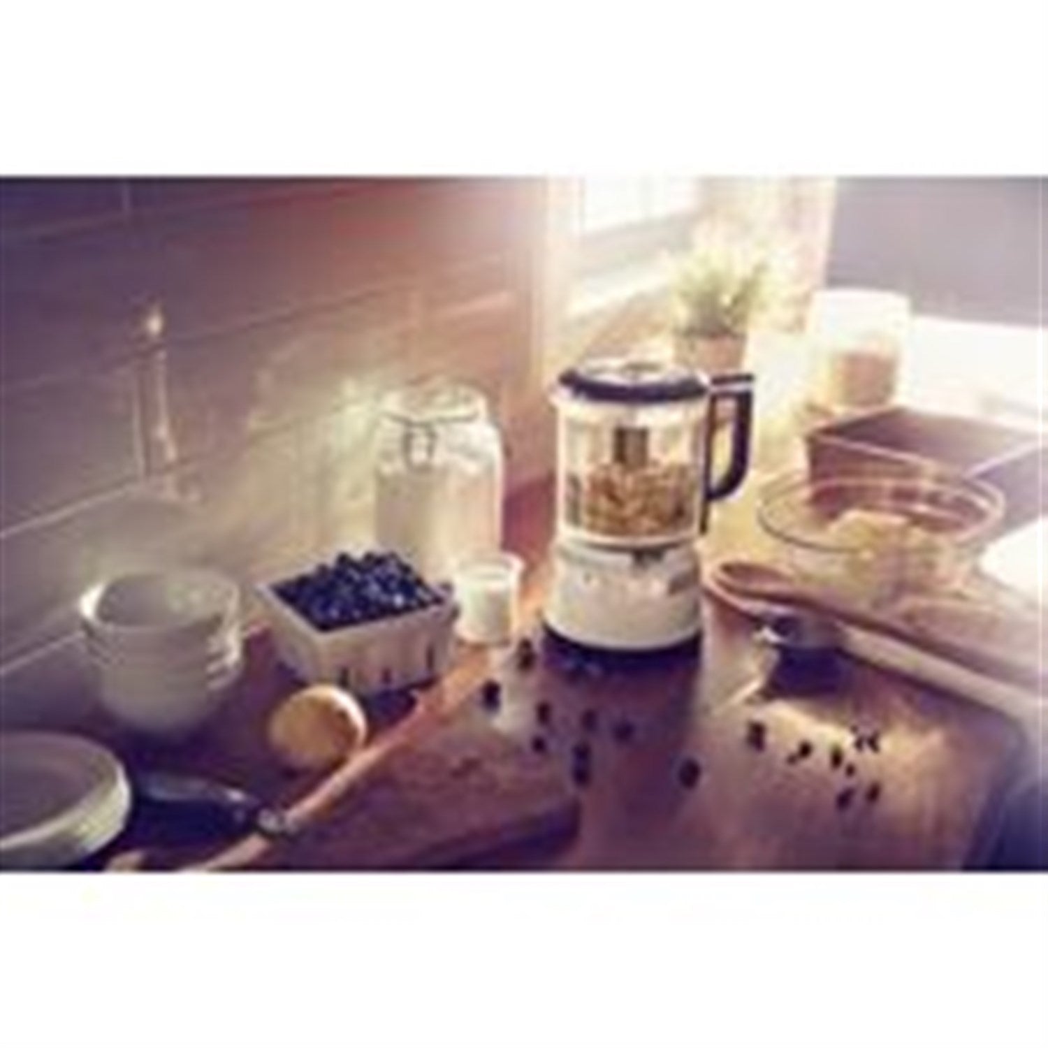 Countertop food chopper with clear bowl in use beside chopped ingredients