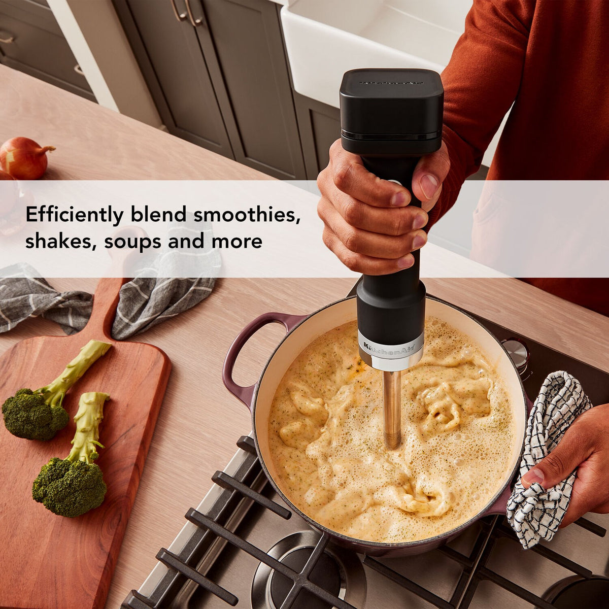 KitchenAid cordless hand blender blending soup in a skillet with stainless shaft